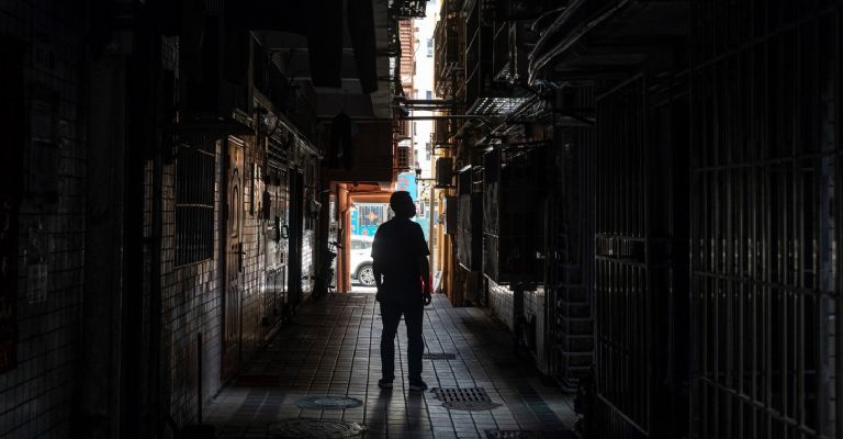 Wu Qunlin frente a su tienda de masajes en Xiasha Village en Shenzhen, China, el 16 de noviembre de 2022. Para ahorrar en el alquiler después de que los cierres comenzaron a afectar su negocio, trasladó su tienda de una calle a un callejón trasero. The New York Times.