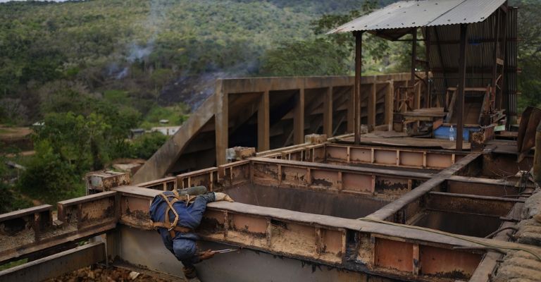 Un trabajador retira placas de hierro en una zona donde se efectúa minería subterránea de oro para reutilizarlas en molinos de piedra en El Callao, estado Bolívar, en Venezuela, el viernes 28 de abril de 2023